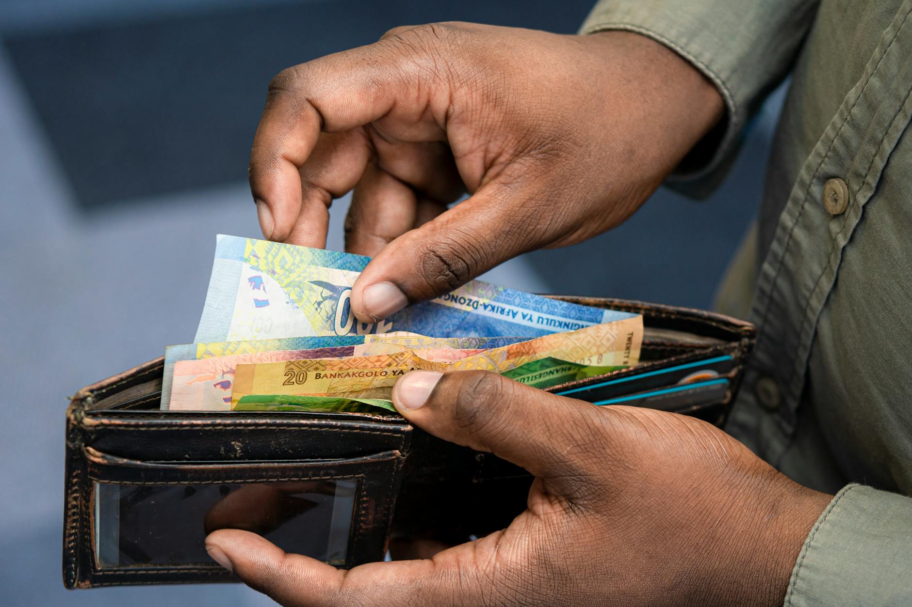 man hands holding wallet and cash