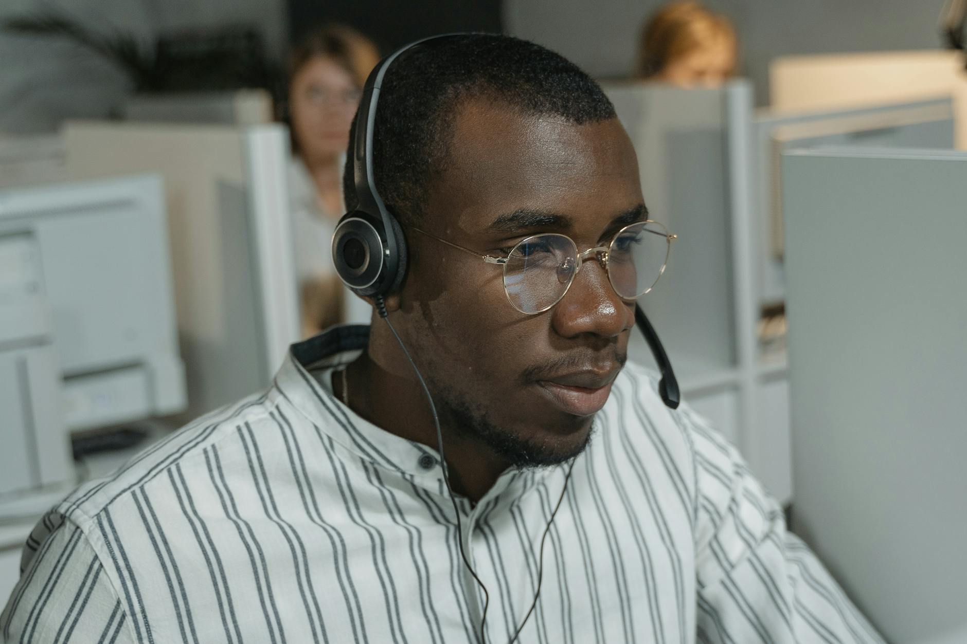 a man in white and black striped button up shirt wearing black headphones