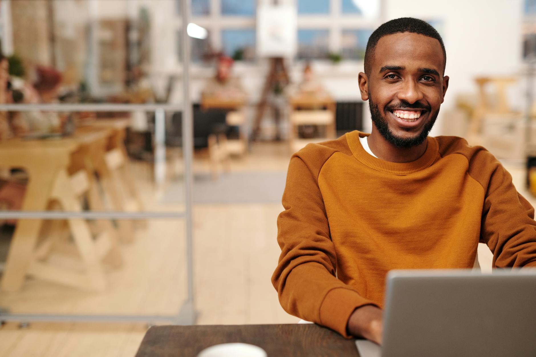 a bearded man in brown sweater smiling