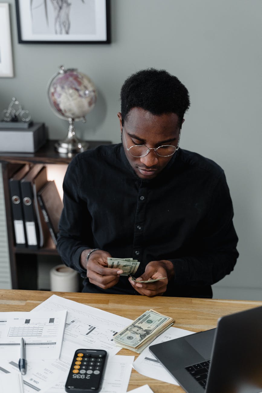 man in black long sleeves holding paper money