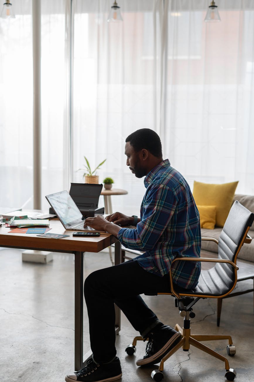 a man in blue plaid long sleeves using a laptop