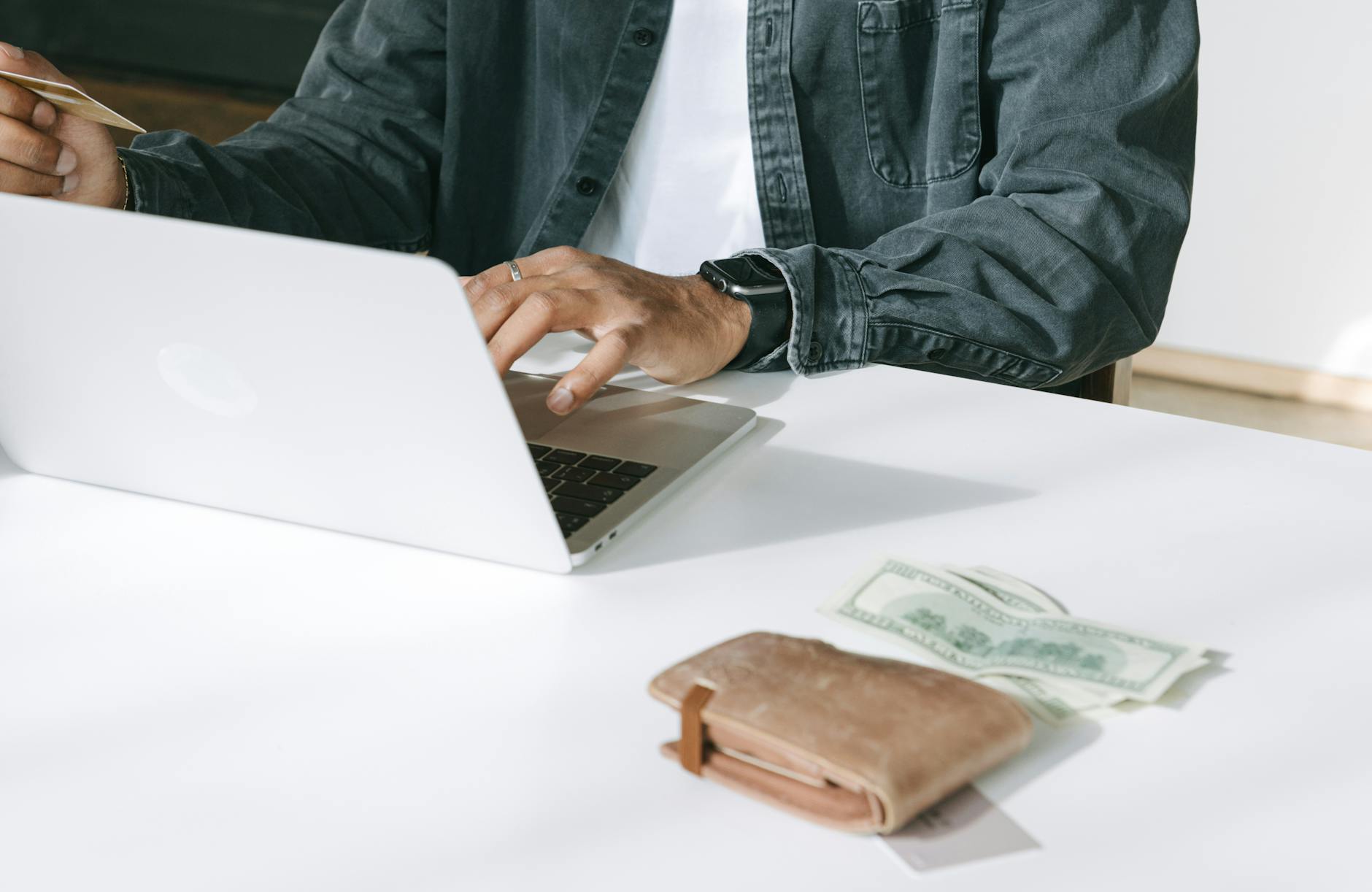 person using laptop on white table top