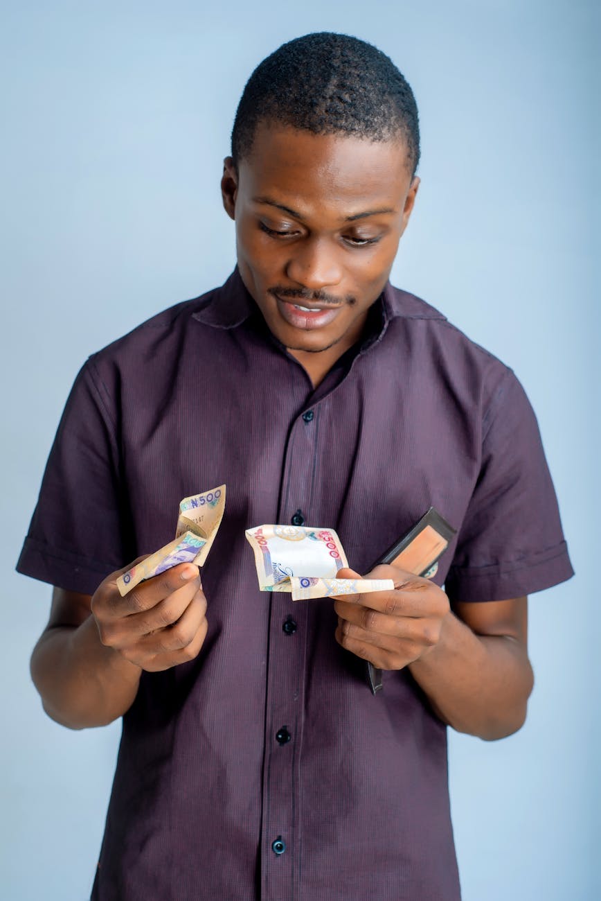 man wearing button up shirt holding money