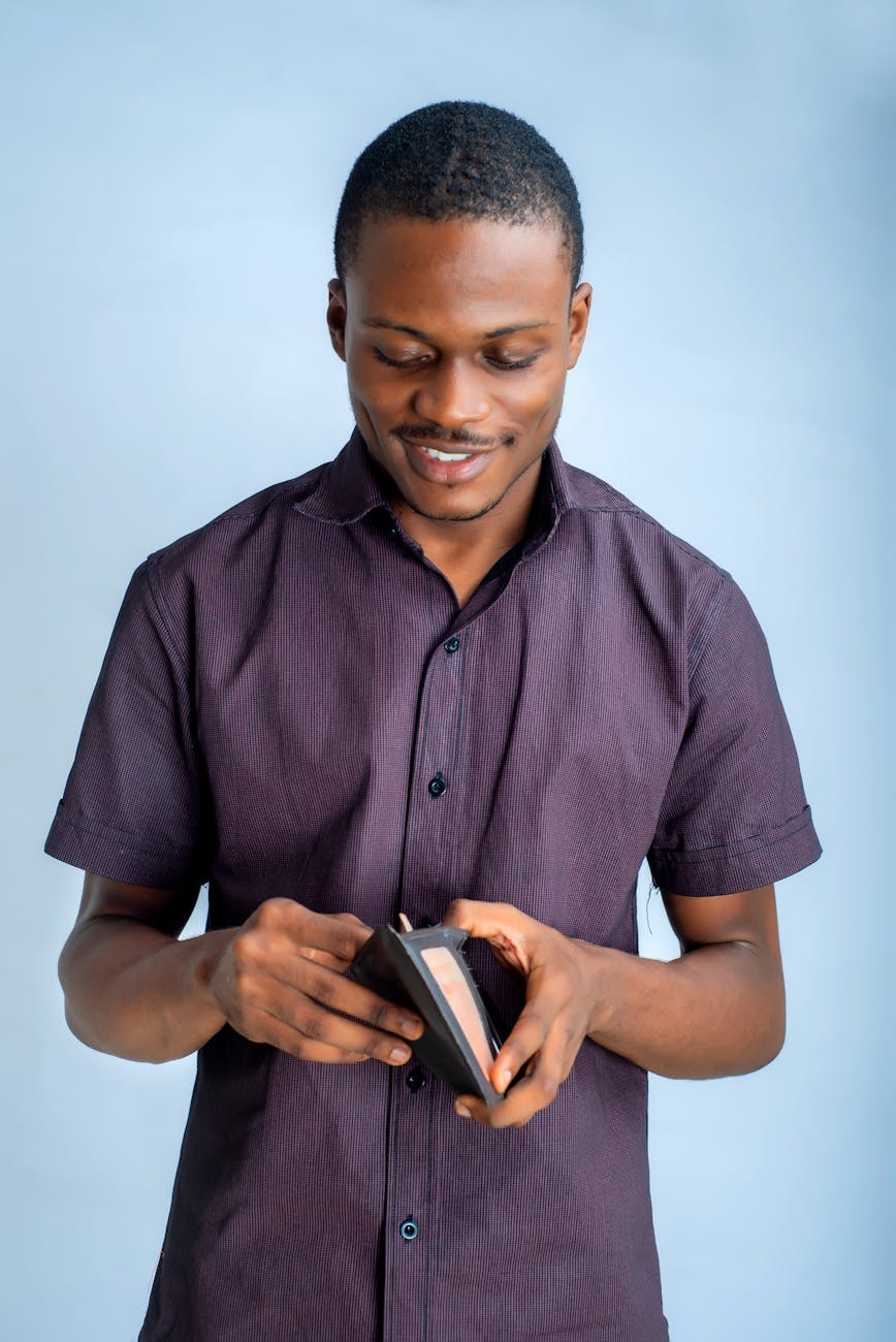 man in button up shirt holding a wallet